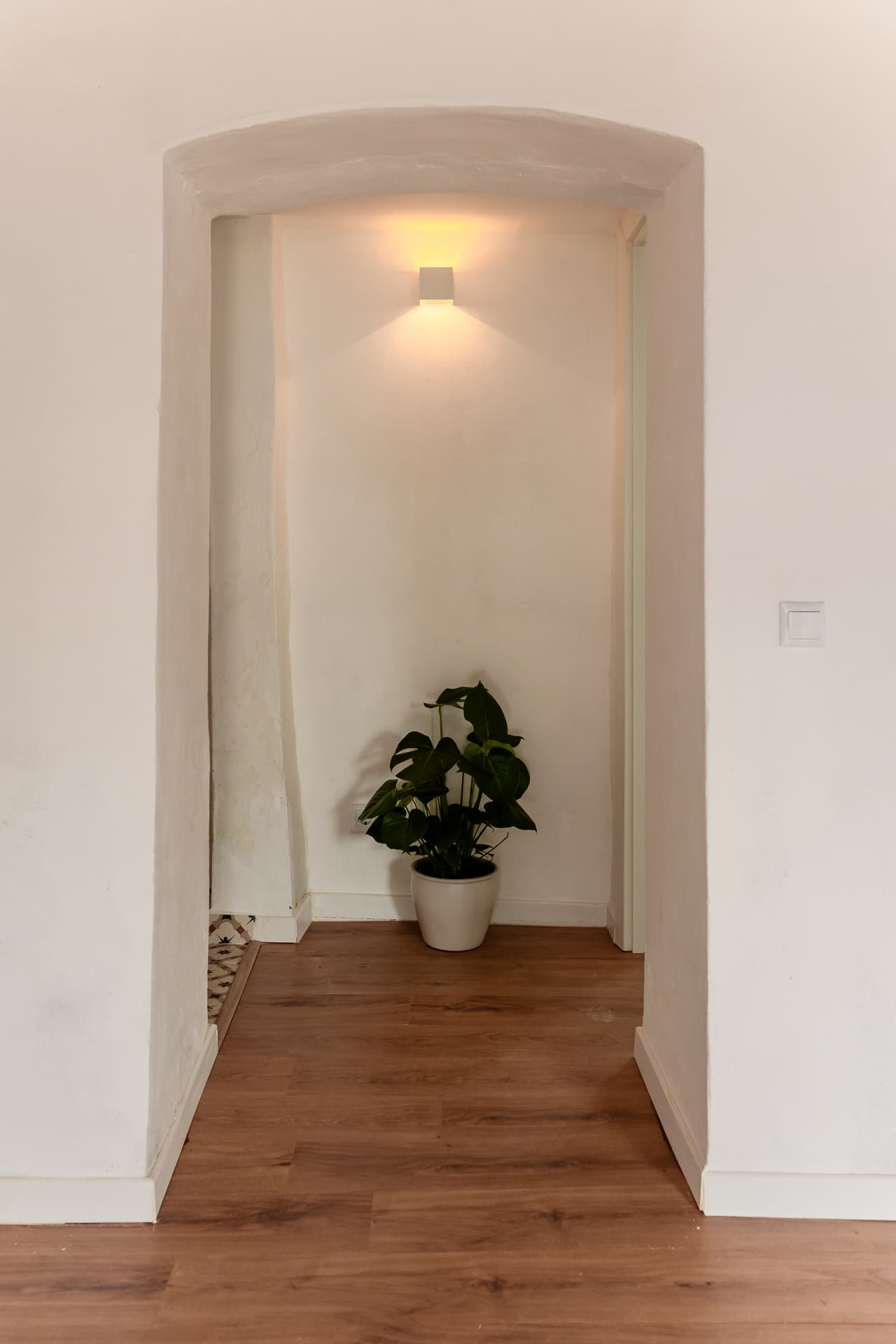 Hall de entrada com arco e pavimento de madeira