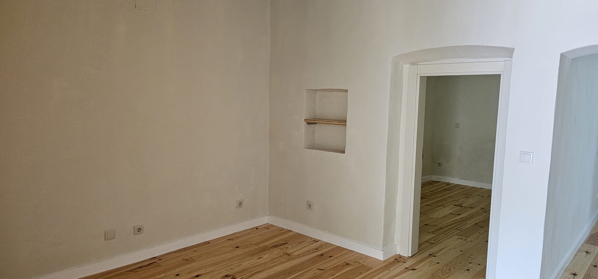 Sala ampla com nicho e soalho de madeira