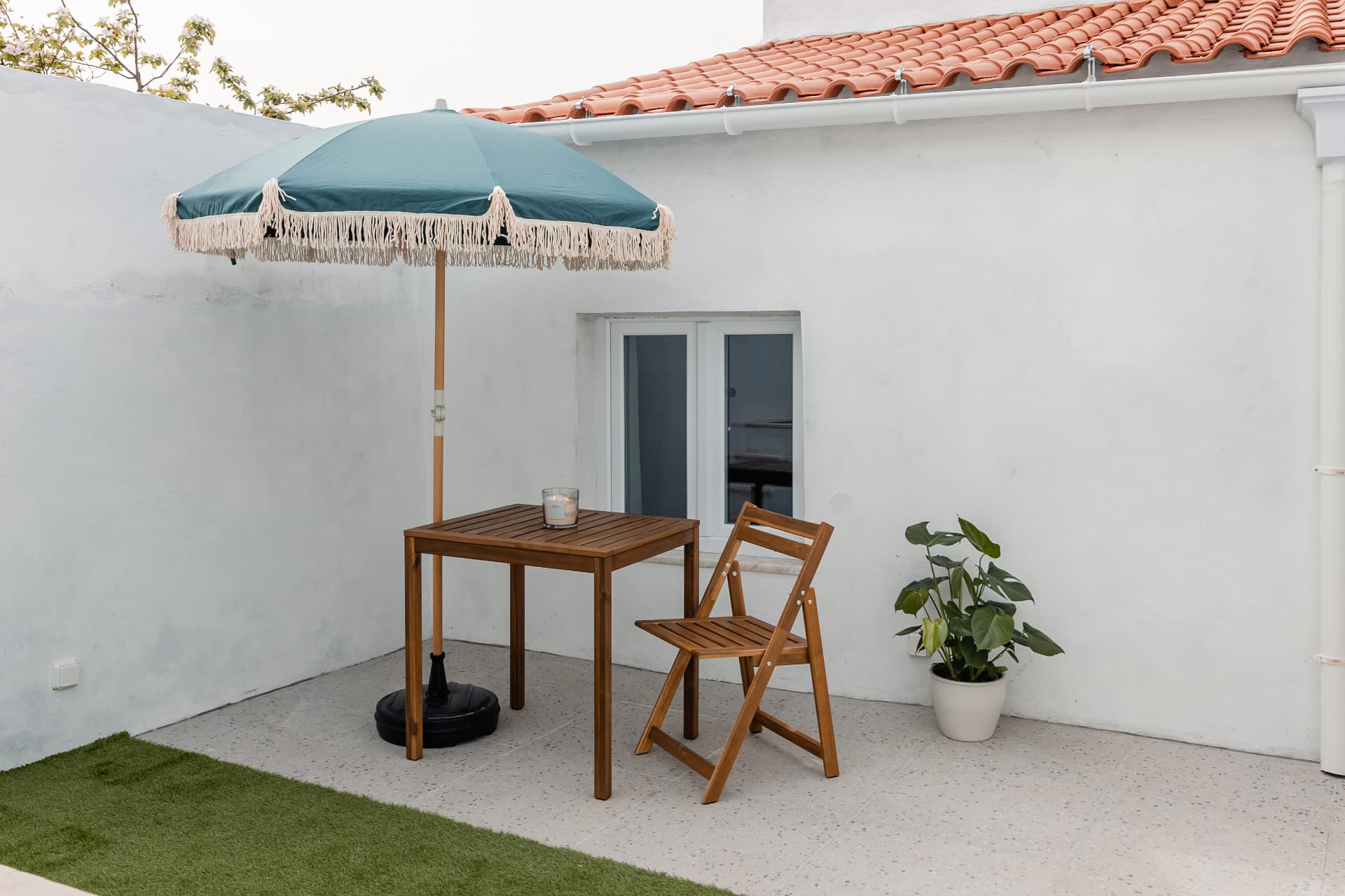 Pormenor do pátio com guarda-sol e plantas
