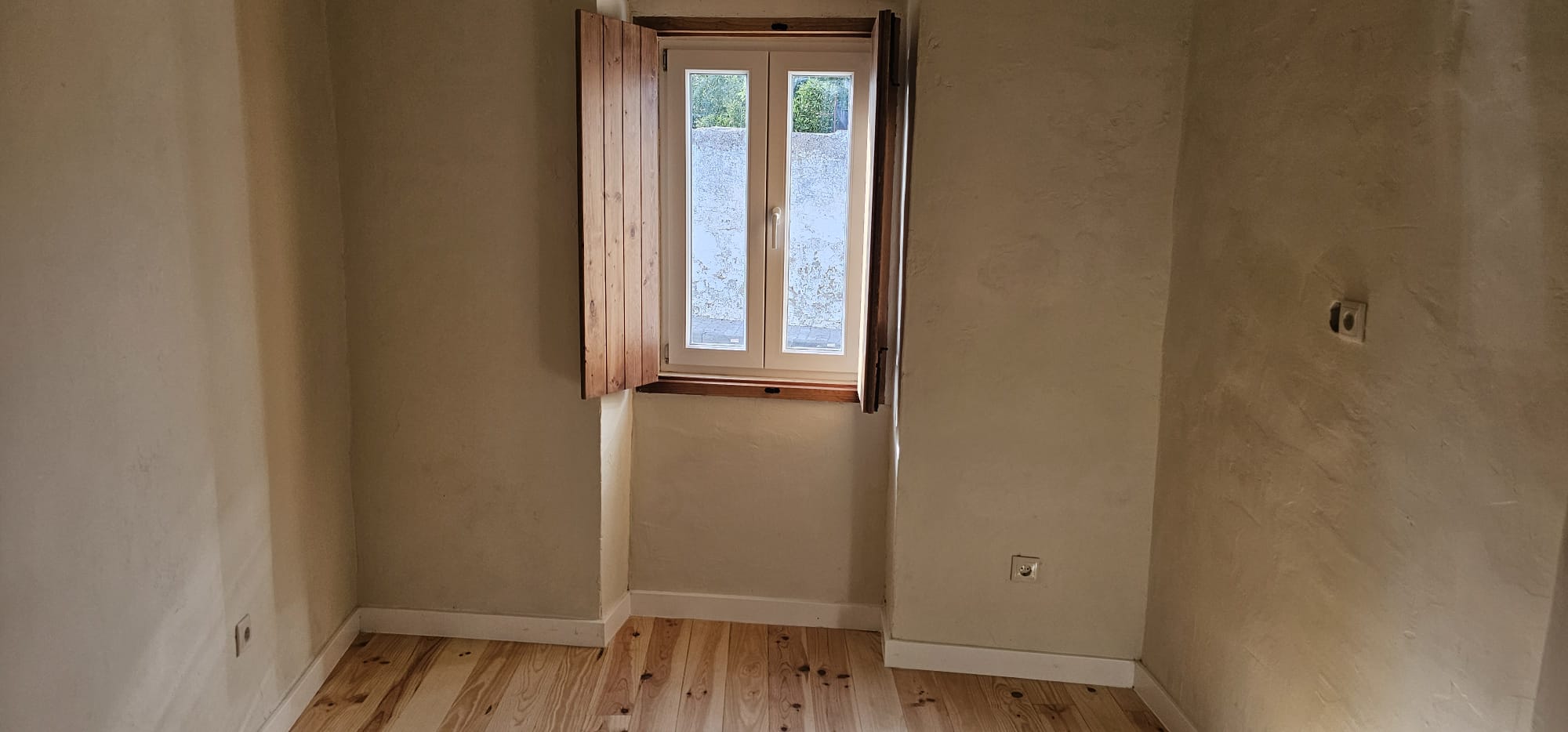 Quarto com portadas interiores em madeira